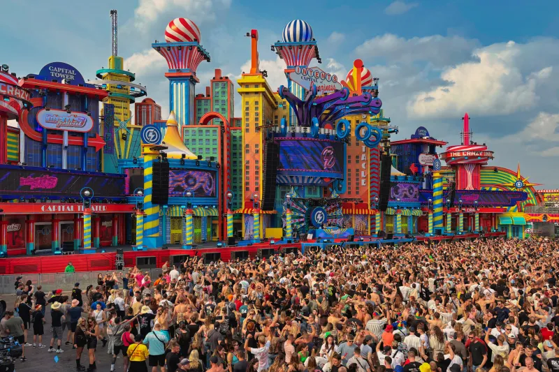 Bunte Bühne mit Luftballons und großer Menschenmenge beim Festival
